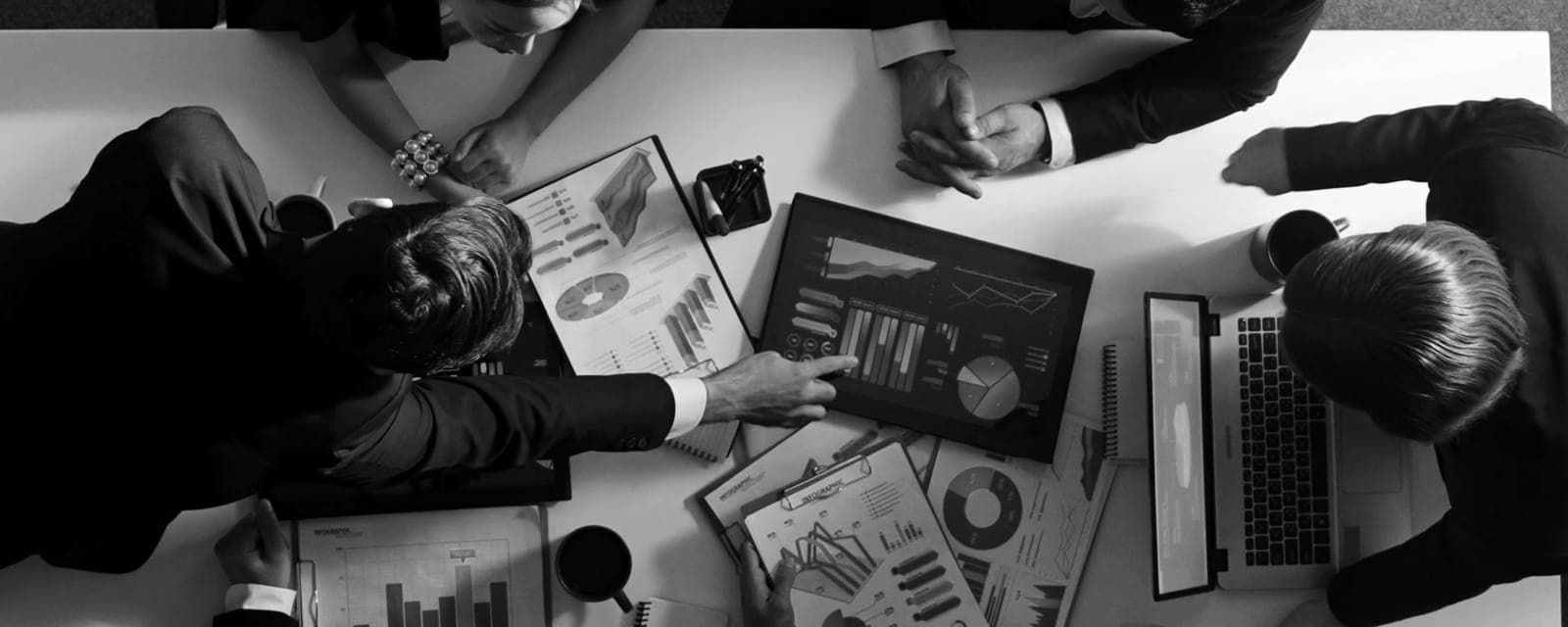 Equipo revisando gráficos de crecimiento, blanco y negro